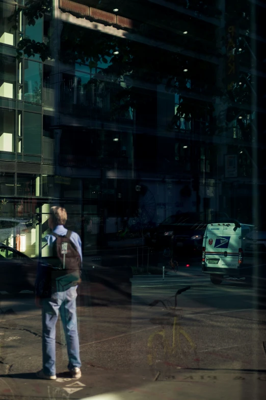 the man is standing outside near a big building