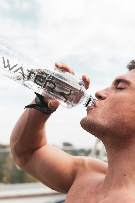 a man drinking water from a bottled bottle