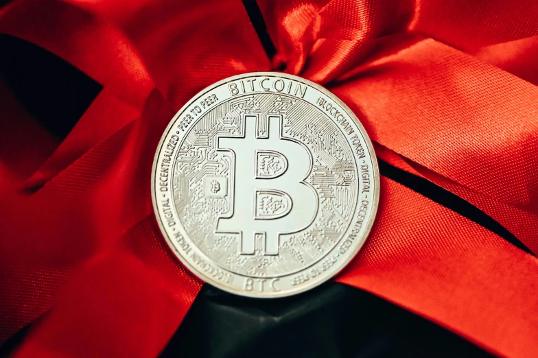 a bit coin is wrapped up with red ribbon