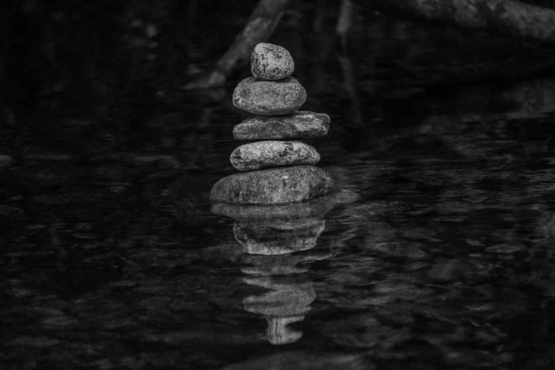stacked rocks sit in the middle of water