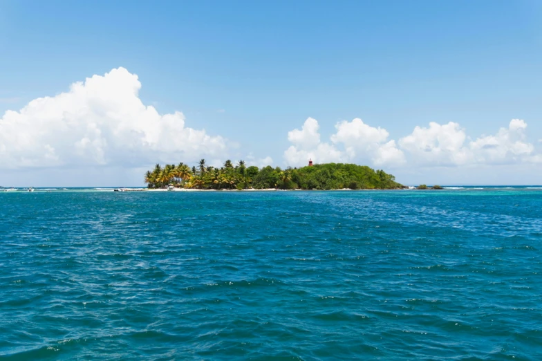 an island is surrounded by water and clouds