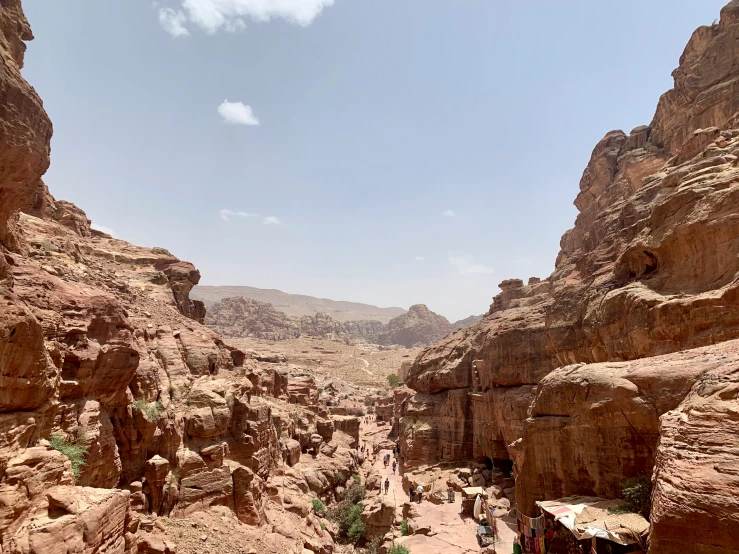 people walking through some rocky cliffs in a valley