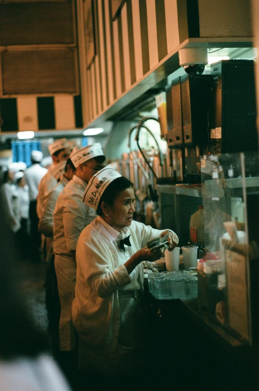 a line of cooks in a kitchen, working in the kitchen