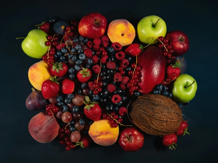 an apple and walnuts are surrounded by berries, bananas, and other fruit