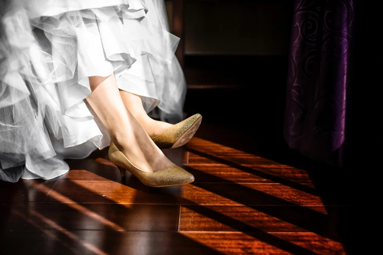 a woman's shoe and dress sitting on the floor in front of her
