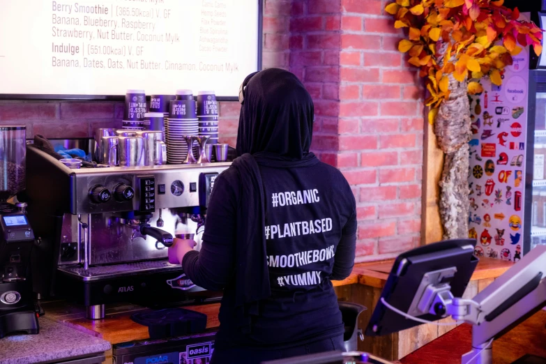 a woman sitting at a coffee machine in a building