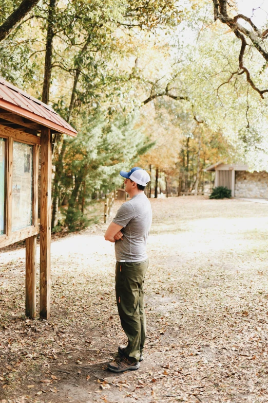 a man looking at an old glass window in the woods