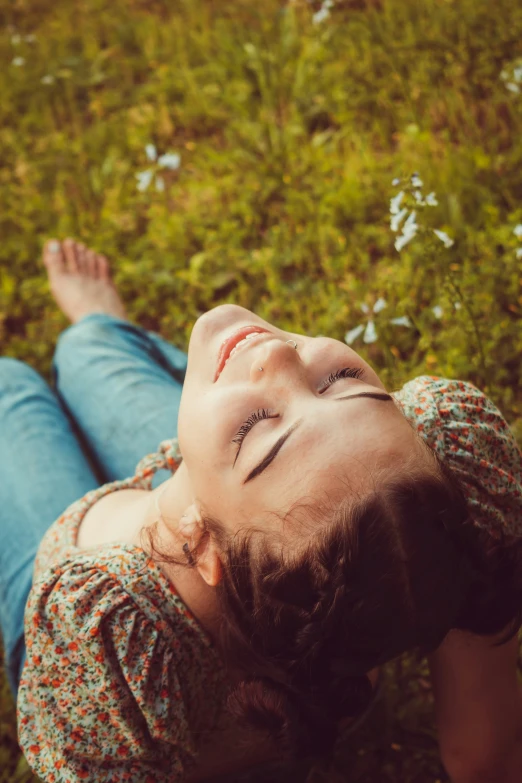 the young child lies on the grass and smiles