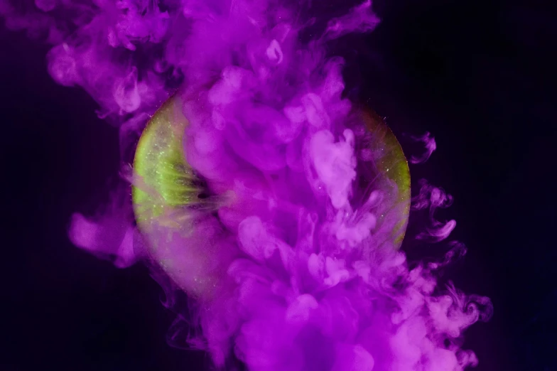 purple and green smoke is floating through the air