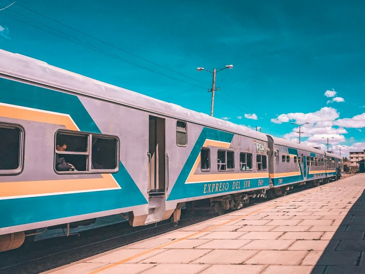 a long passenger train stopped at a station