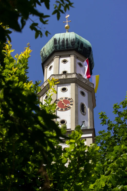 the spire of a white building with a red cross on it