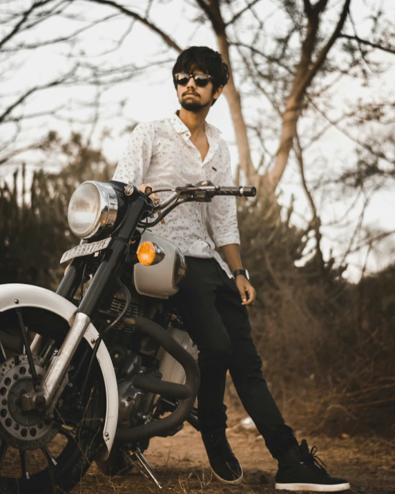 a young man is posing with his motorcycle