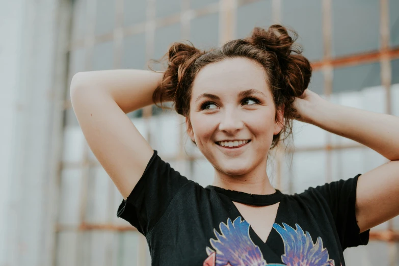 woman with her hair in a pony tail smiles at the camera