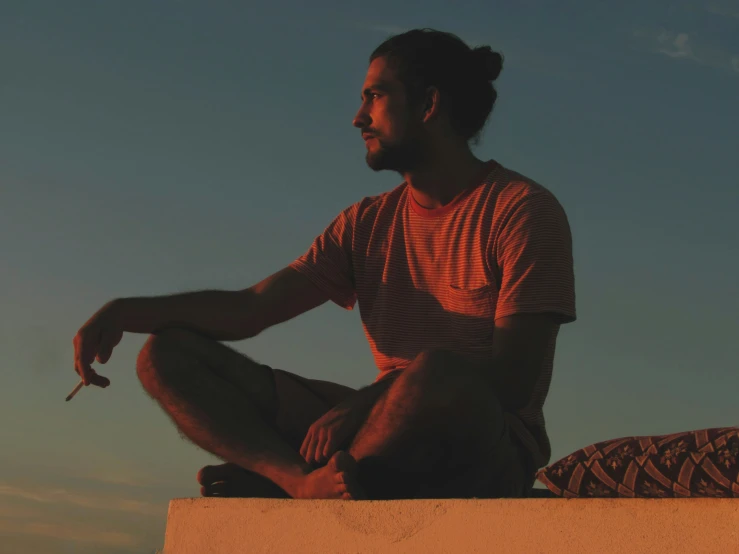 a man that is sitting on top of a wall