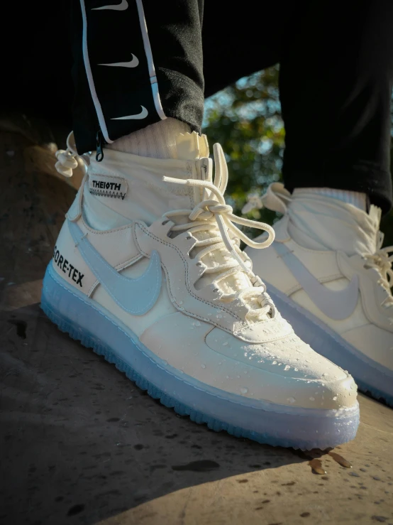 a person in white shoes standing with their leg on a skateboard