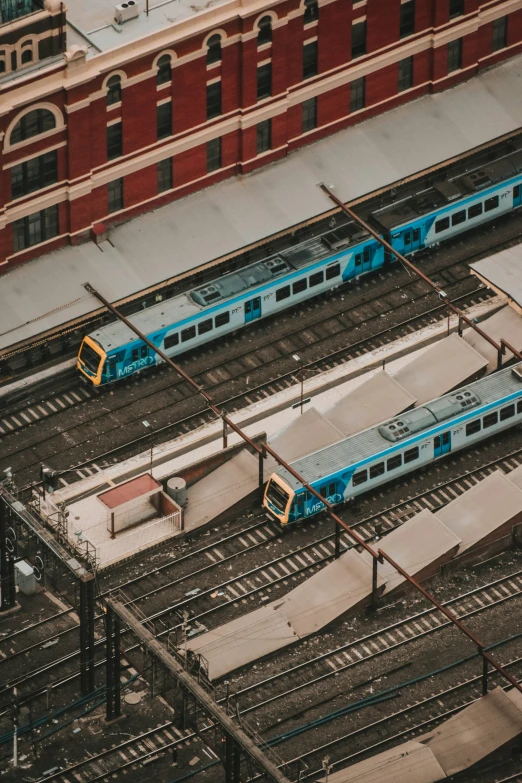 multiple trains parked on train tracks in front of a building