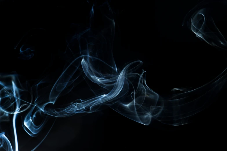 smoke moves along against a black background