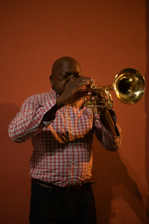 man playing trumpet in the dark of night