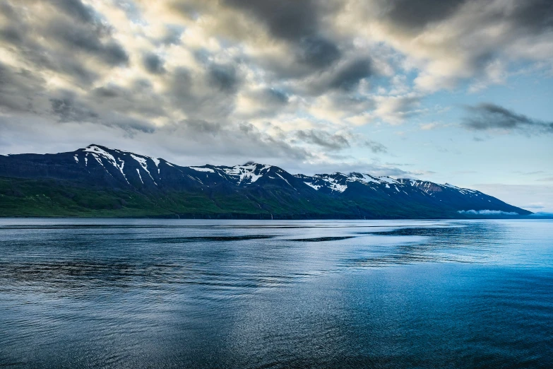 a body of water with mountains in the background