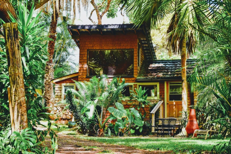 this house is surrounded by lush green trees and shrubs