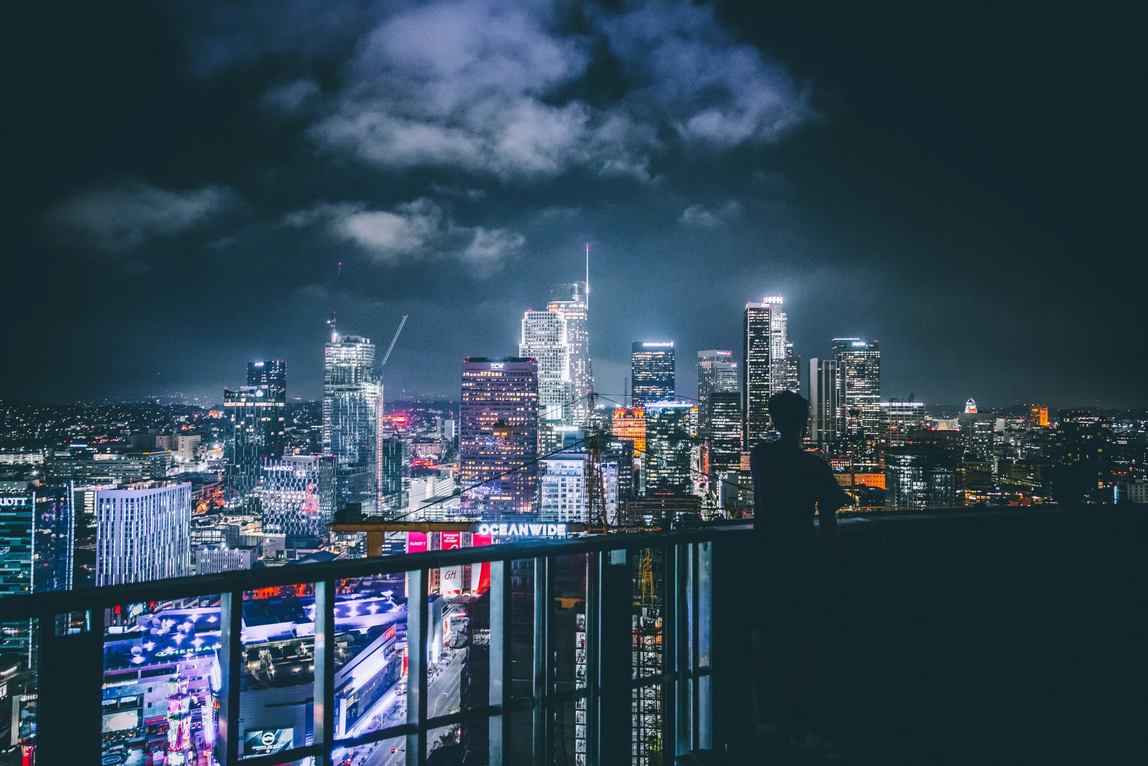 city skyline in the night with cars coming down the road