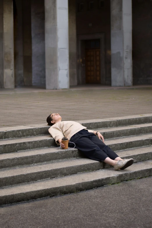 the man is laying down on the stairs with his foot up