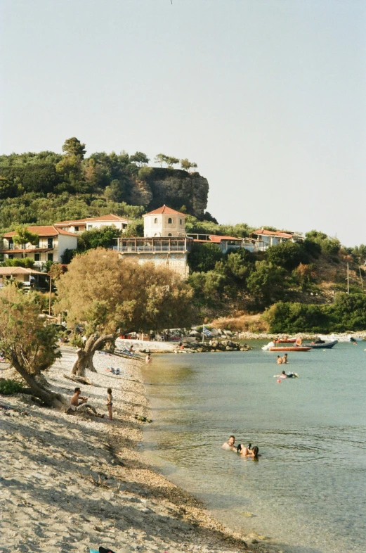 beach with people swimming in the ocean and onlookers