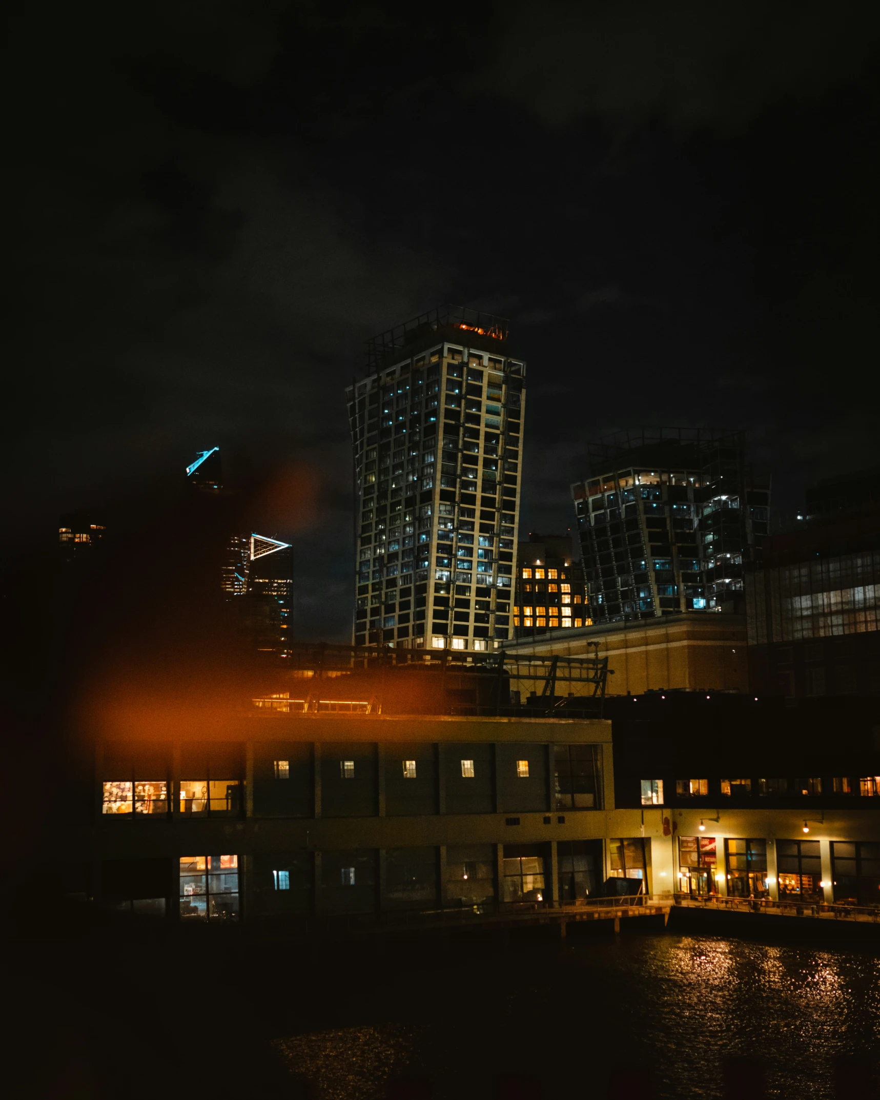 cityscape at night lit up with windows reflecting light