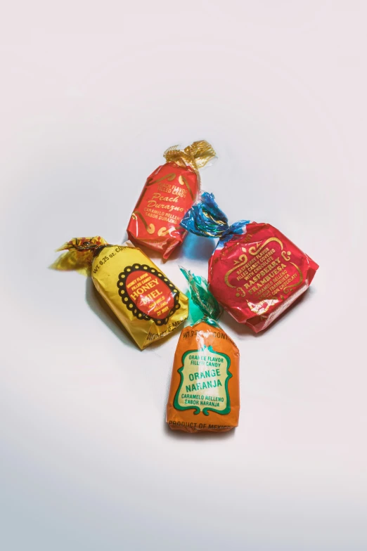 three bags with different types of candies on white surface