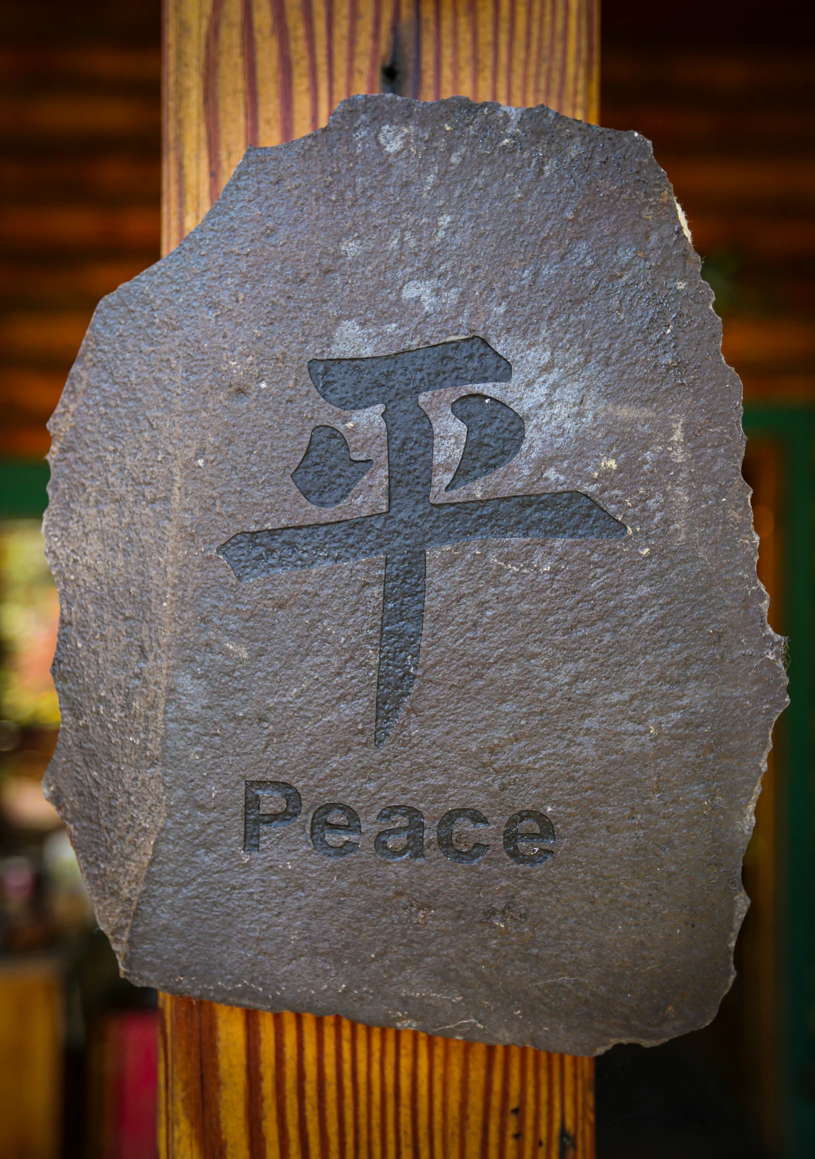 a stone with a tree in front of a sign