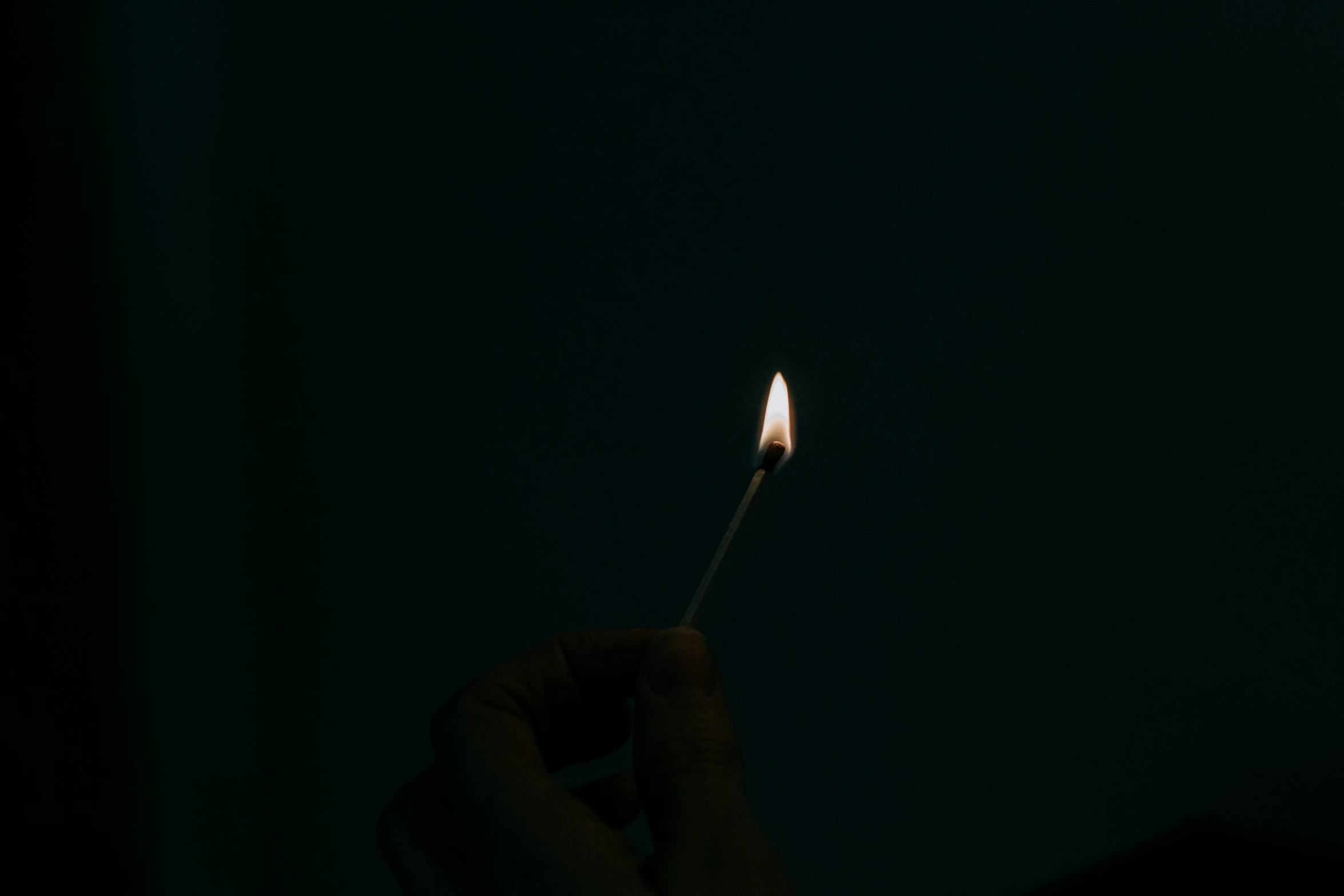 someone holding a lit candle in their hand