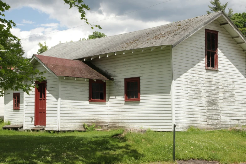 an old rundown church with a very large red door