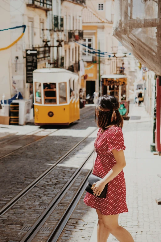 a woman walking on the street next to a train