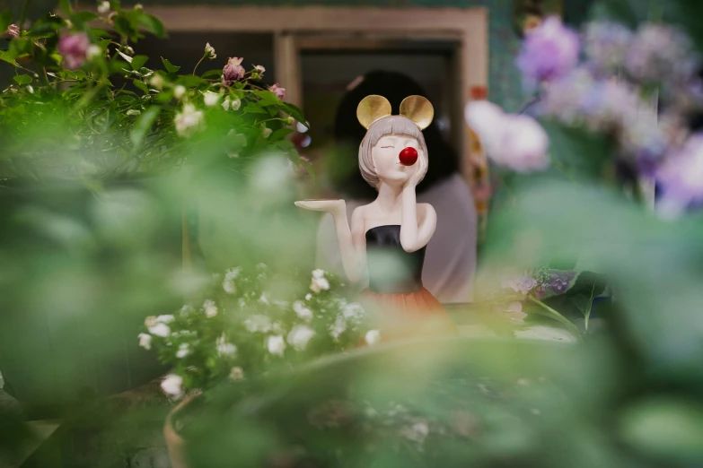 a white deer standing in front of some purple flowers