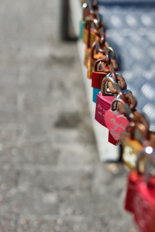 many colorful padlocks attached to a blue metal wall