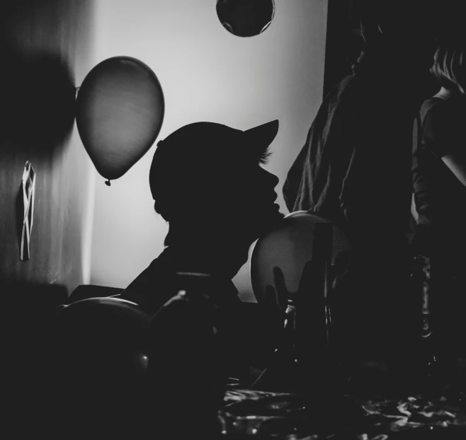 a black and white po of a person with balloons
