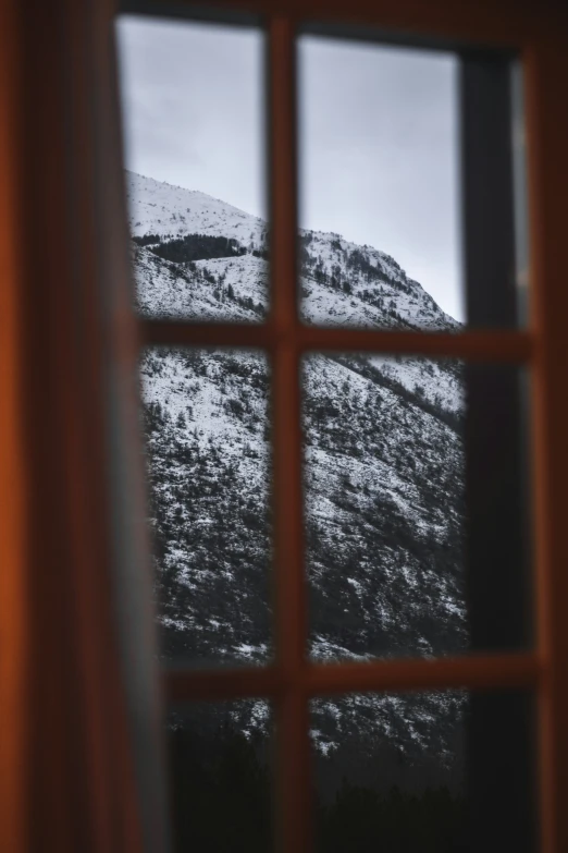 a window looking out at a mountain outside