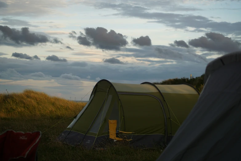 a tent with it's door open sitting on a field