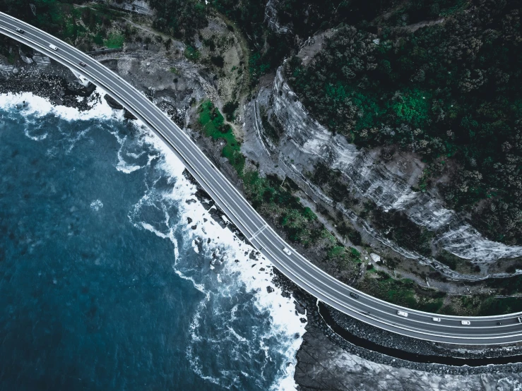 a freeway on the ocean shore with a car driving by