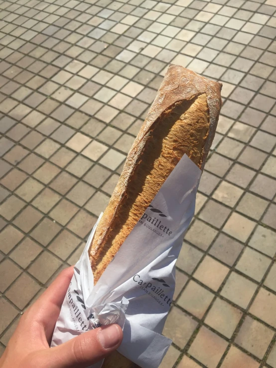 someone holding a bread in their hand with the crust on top