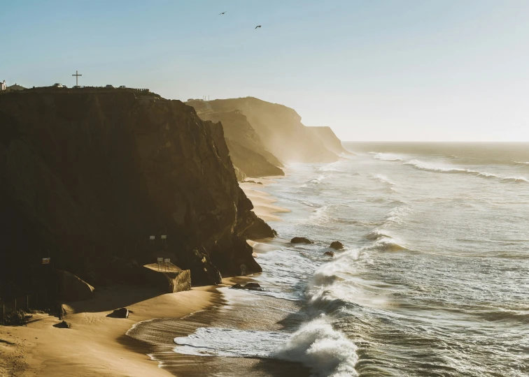 beach area with cliff overlooking the ocean on a sunny day