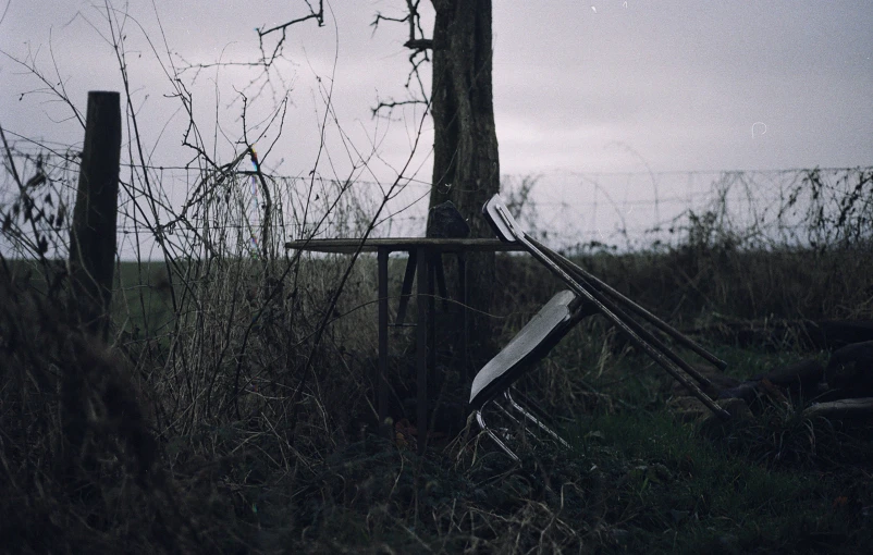 an old chair is left behind by the wooden post