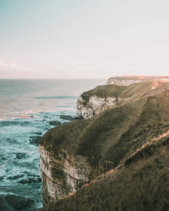 cliffs by a body of water next to the beach