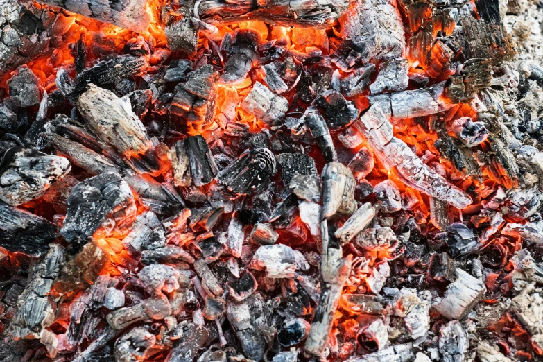 a bunch of  coals cooking over a fire