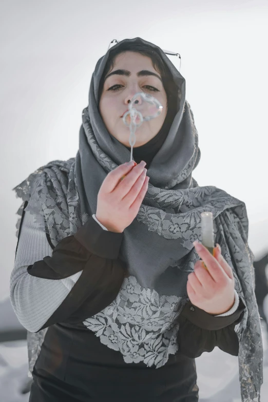 an image of a young woman blowing soap on a stick