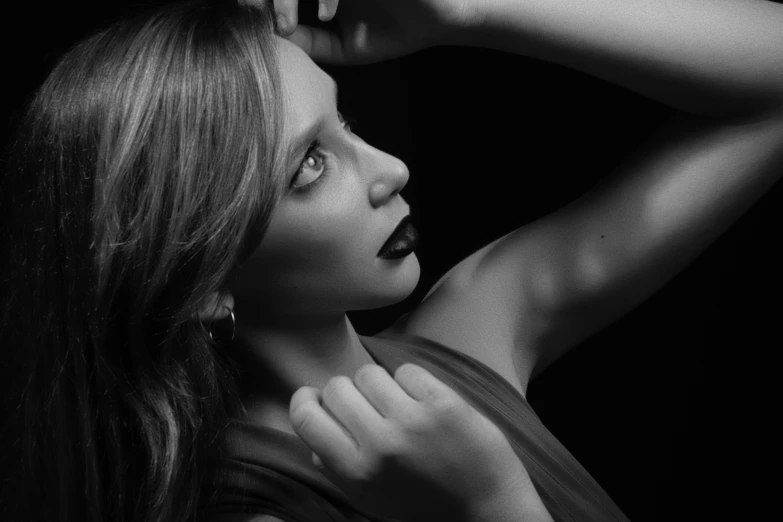 a woman posing in black and white with her hands behind her head