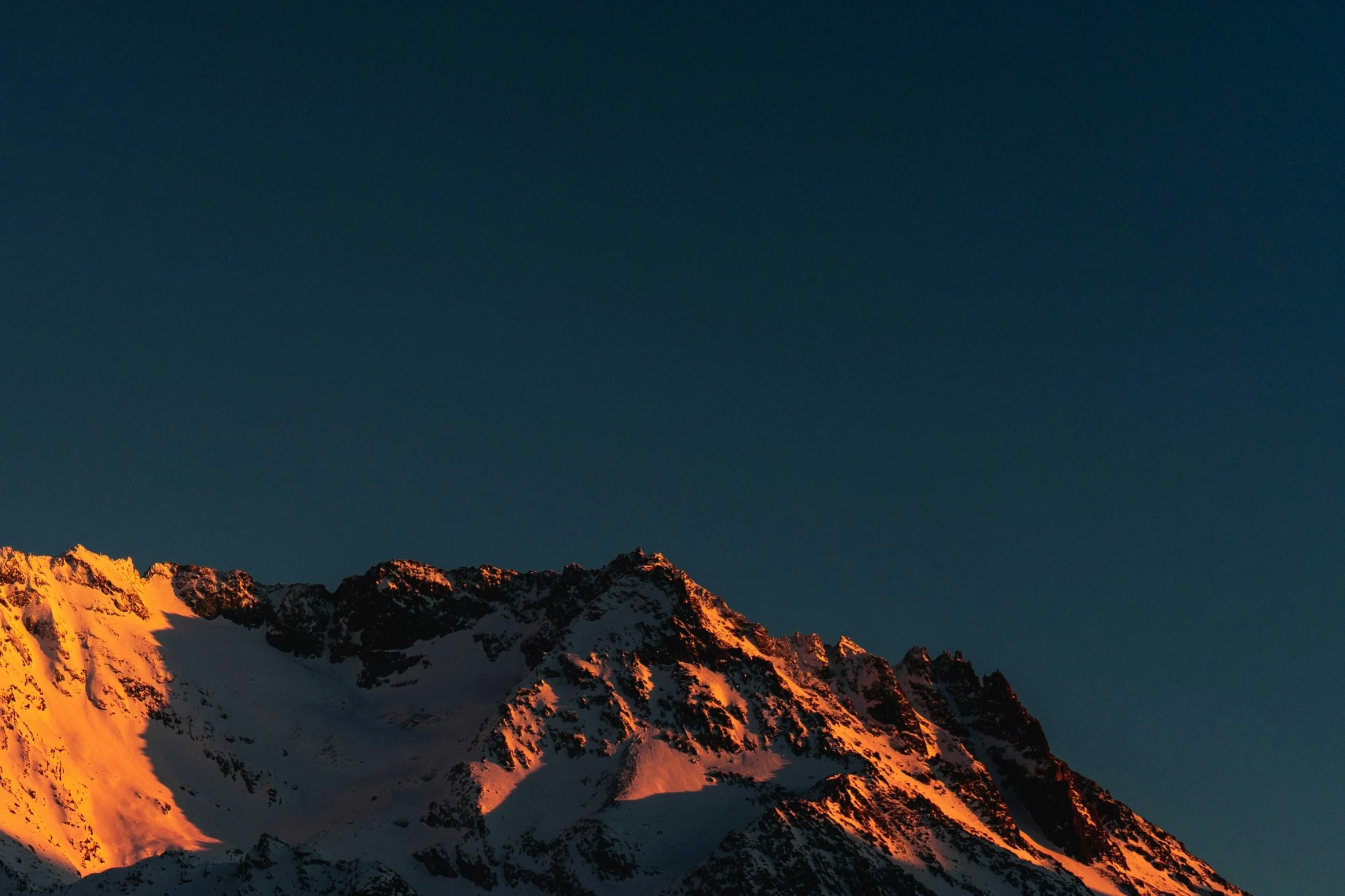 a snow covered mountain is shown with the sun