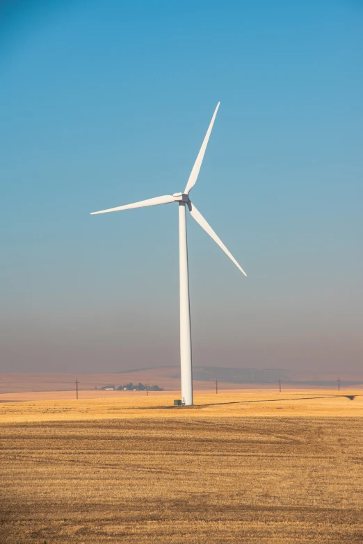 a lone wind mill in an empty desert plain