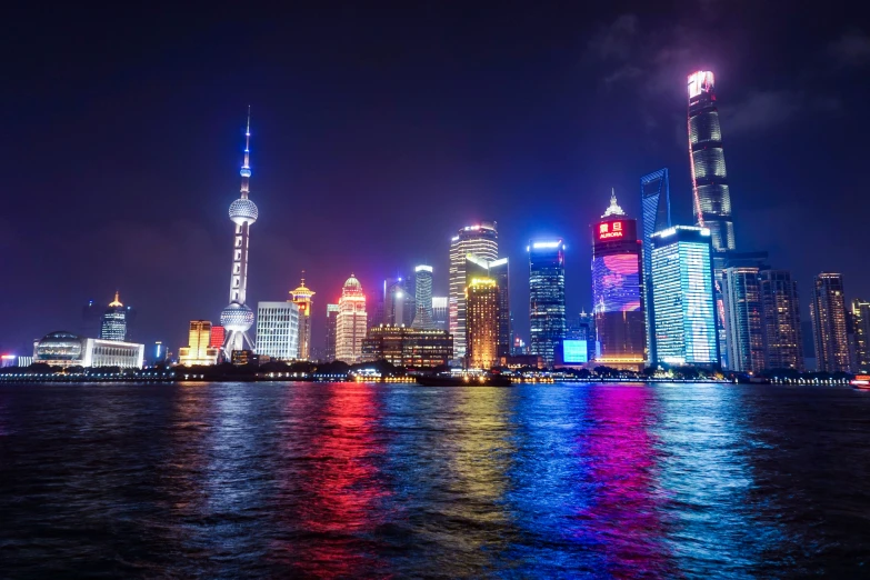 a city skyline lit up at night from the water