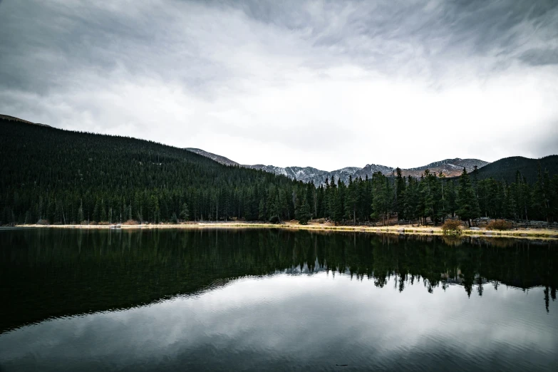 a large body of water surrounded by trees and mountains